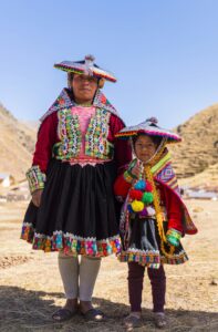 Mujer y niña con trajes típicos de Cusco, destacando los colores y patrones tradicionales de la vestimenta andina