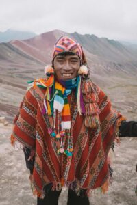 Un hombre vistiendo ropa tradicional andina con colores llamativos, representando la cultura de la región.